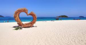 a heart shaped sculpture on a sandy beach at Lipe Beach Resort in Ko Lipe