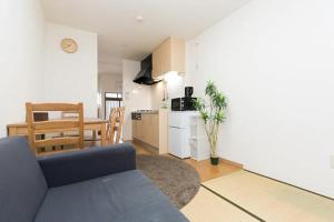 Il comprend un salon avec un canapé bleu et une cuisine. dans l'établissement EX2 Higashimikuni Hous, à Osaka