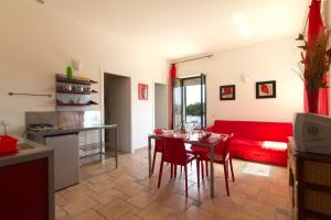 un soggiorno con un divano rosso e un tavolo di B&B Neptunia fronte mare a Torre Specchia Ruggeri