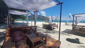 a tent on a beach with a table and a bench at Lipe Beach Resort in Ko Lipe
