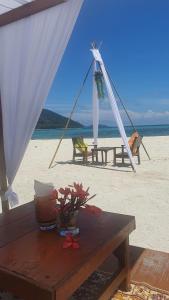 a picnic table on the beach with a tent at Lipe Beach Resort in Ko Lipe