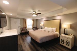 Habitación de hotel con cama y ventilador de techo. en Riverbend Motel & Cabins en Helen