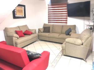 - un salon avec deux canapés et un canapé rouge dans l'établissement Villas Coral Deluxe, à Manzanillo