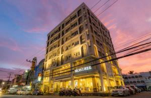 a building on a street with cars parked in front of it at Montree Phuket Hotel in Phuket Town