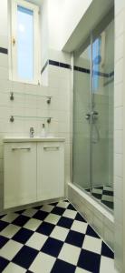een badkamer met een glazen douche en een geruite vloer bij Highlight Apartment Naschmarkt in Wenen