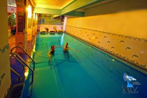 焦特布爾的住宿－克里希納普拉卡什哈維麗傳統酒店，两个人在游泳池玩耍