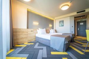 Habitación de hotel con 2 camas y suelo amarillo y azul en HVD Club Bor - 24 Hours Ultra All Inclusive en Sunny Beach