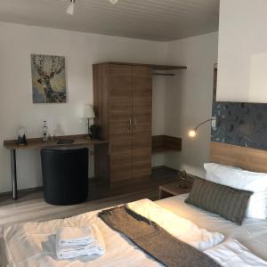 a bedroom with a bed and a desk in it at Hotel Berghof by 42 in Koblenz