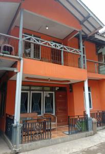 un bâtiment orange avec un balcon au-dessus dans l'établissement Pondok orange ciwidey, à Bandung