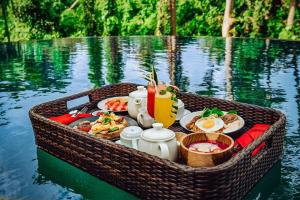 un panier de nourriture sur un bateau dans l'eau dans l'établissement Tanamas Villas Ubud by Best Deals Asia Hospitality, à Ubud