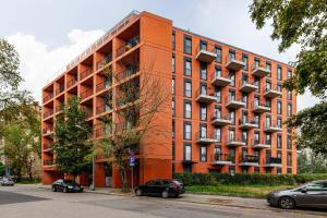 un edificio anaranjado con coches aparcados delante de él en Apartment Praga Center by Renters, en Varsovia