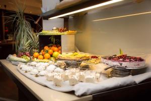 um buffet de frutas e sobremesas numa mesa em Hotel Du Col em Sestriere