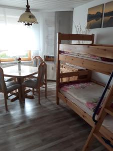 Pokój ze stołem i łóżkiem piętrowym w obiekcie Ferienwohnung - Waldwichtel w mieście Reudnitz