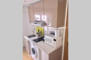 a kitchen with a washing machine and a microwave at French typical apartment (opéra 5D) in Paris