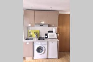 a kitchen with a washing machine and a microwave at French typical apartment (opéra 5D) in Paris