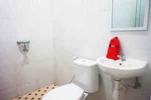 biała łazienka z toaletą i umywalką w obiekcie RedDoorz @ Jalan Tanjung Blitar w mieście Blitar