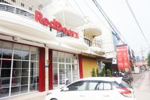 a white car parked in front of a building at RedDoorz @ Jalan Tanjung Blitar in Blitar
