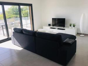 un sofá negro en una sala de estar con TV en Bela Concha - Bela Baia 3 en Salir de Porto