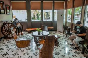 a group of people sitting in a living room with a wheel at Oxville Hotel in Padang