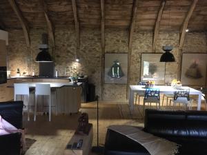 a living room with a kitchen and a table at Le Gîte du Château de Durfort in Soursac