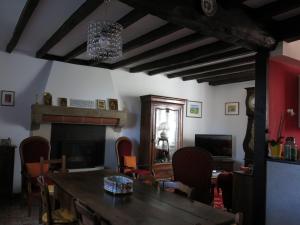a dining room with a table and a fireplace at Au Relais de Nèche. in Bègues