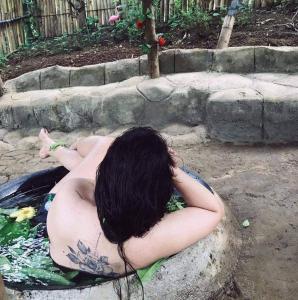 Antipolo Rizal -Tent Site-Forest Camp Adventure-with Hike & Climb في أنتيبولو: امرأة تجلس في حوض الاستحمام