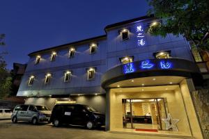 un edificio con coches estacionados frente a él en Gorgeous Hot Spring Resort, en Taipéi