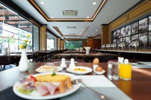 a restaurant with plates of food on a table at Picnic Hotel Bangkok - Rang Nam in Bangkok
