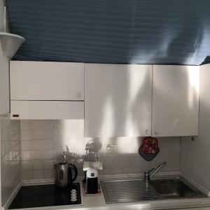 a kitchen with white cabinets and a sink at Petit avec classe Sanremo in Sanremo