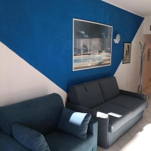 a living room with a couch and a blue wall at Petit avec classe Sanremo in Sanremo