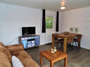 ein Wohnzimmer mit einem Sofa, einem Tisch und einem TV in der Unterkunft Luxe Chalet Oostkapelle OK28 in Oostkapelle