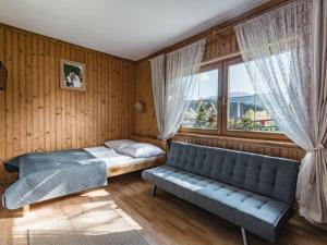 1 dormitorio con sofá, cama y ventana en U Majerczyka II, en Zakopane