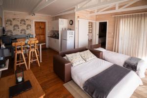a bedroom with a bed and a kitchen with a table at Big Sky Cottages in Wolseley