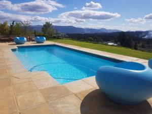 una piscina con sedie blu su un patio di Big Sky Cottages a Wolseley