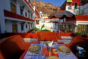 een tafel en stoelen op een balkon met een parasol bij Krishna Prakash Heritage Haveli in Jodhpur +35 foto's