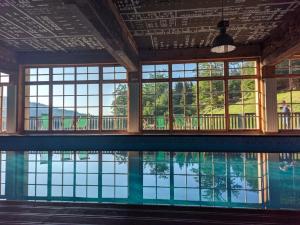a pool in a building with windows and a swimming pool at Smeštaj Iver in Mokra Gora