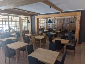 a restaurant with tables and chairs and windows at Smeštaj Iver in Mokra Gora