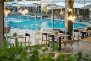 a restaurant with tables and chairs and a swimming pool at HVD Viva Club Ultra All Inclusive - Private Beach & Free Parking in Golden Sands +76 photos