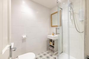 a white bathroom with a shower and a sink at Gorgeous Garden Apartment in Bath +22 photos