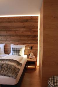 - une chambre avec un lit et un mur en bois dans l'établissement Living Studio Pia, à Sankt Anton am Arlberg