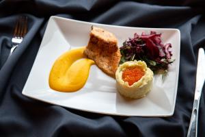 a plate of food with a slice of bread and a orange peel at Karlamuiza Country Hotel in Kārļi