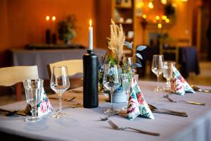 a table with a candle and wine glasses on it at Karlamuiza Country Hotel in Kārļi