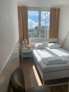 Un dormitorio con una cama y una ventana grande. en Hotel Sphinx, en Ámsterdam