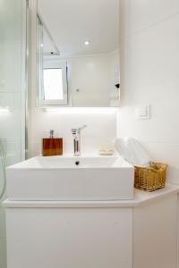 a white bathroom with a sink and a mirror at Katerina's home in Heraklio