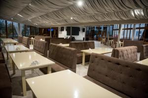 a restaurant with white tables and chairs and windows at Holiday stay Nika in Busk