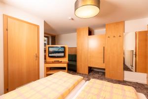 a bedroom with two beds and a tv in it at Hotel-Garni Pramstraller in Mayrhofen