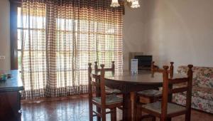 a dining room with a table and chairs and a couch at VILLA ROSA in Duna Verde +5 photos