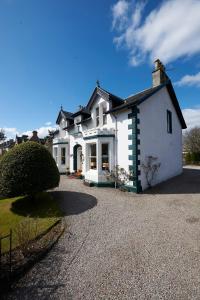 una gran casa blanca con una entrada de grava en Moyness House, en Inverness