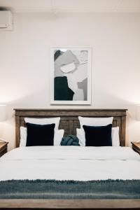 1 dormitorio con 1 cama grande con sábanas y almohadas blancas en Tomfoolery Winemaker's Cottage Barossa Valley, en Lights Pass