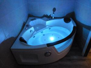 a bath tub with a blue light in a bathroom at Intimo y Acogedor "algunos" con Bañera Hidromasaje in Valencia